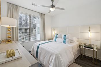 a white bedroom with a large bed and a ceiling fan at Link Apartments® Broad Ave, Memphis, Tennessee